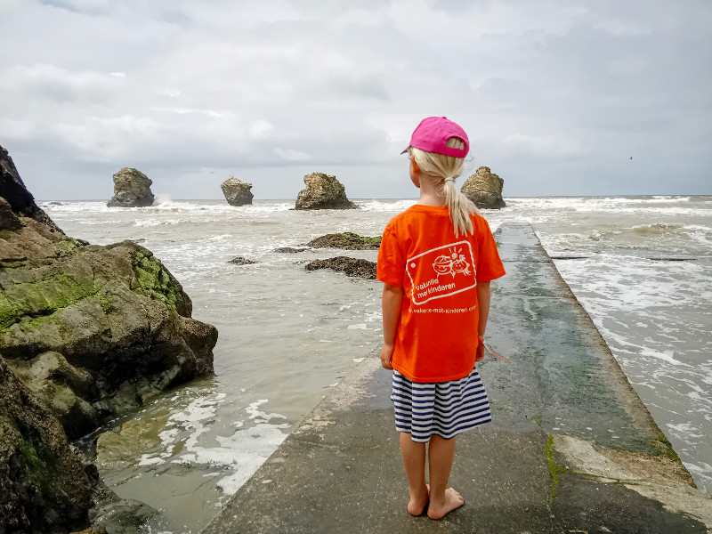 Onze dochter bekijkt de rotsen in de zee van La Corniche vendéenne