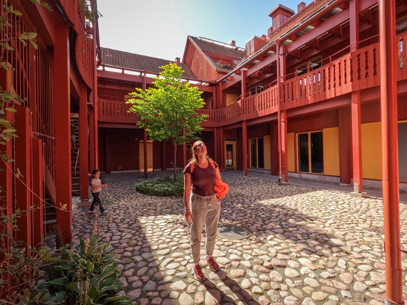 Lisette loopt tussen de historische houten huizen van Eksjo, Zweden