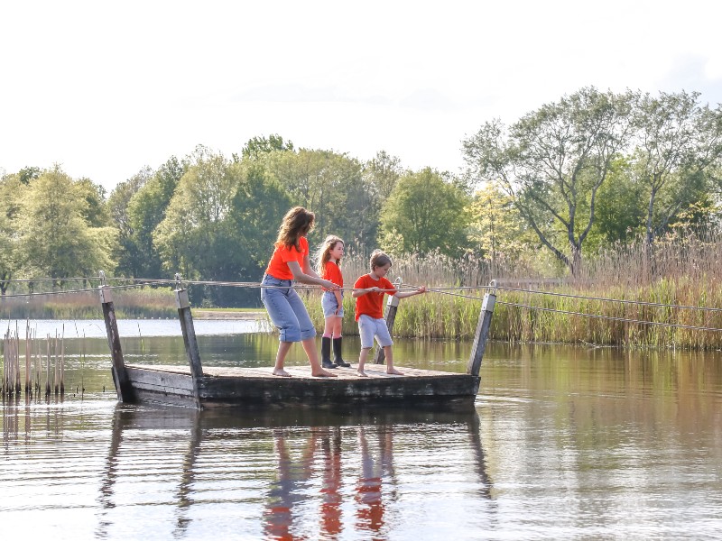 Elisabeth en haar kinderen op het trekvlot, tijdens een wandeling door recreatiegebied de Groene Ster. Dit gebied ligt op 10 minuten lopen vanaf de receptie van camping de Kleine Wielen in Friesland.