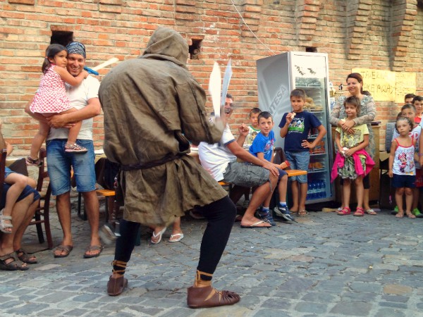 Een acteur vermaakt de kinderen in kasteel Gradara