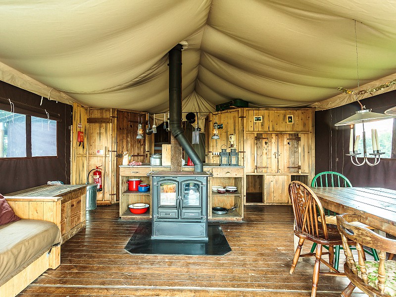 Het interieur van een Boerenbed tent, met houtkachel, bedstee en olielampen