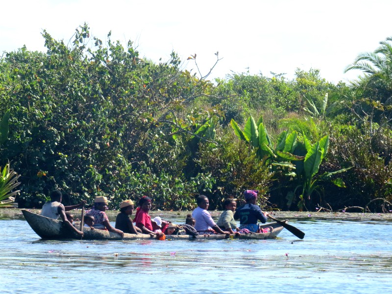 Een familie vervoert zich per kano over het Pangalanes kanaal