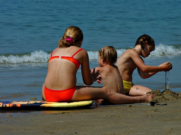 Gezin zit aan de rand van de zee