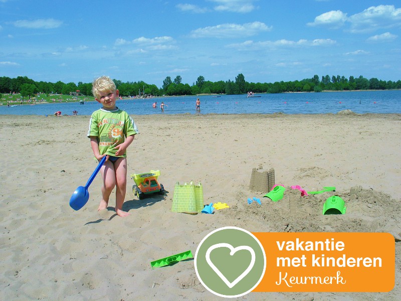 Zeb op het strandje van het recreatiemeer met keurmerk logo