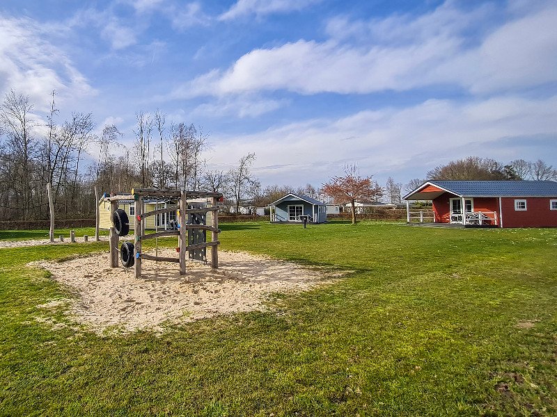 Kampeerveld met speeltoestel, accommodaties en kampeerplekken