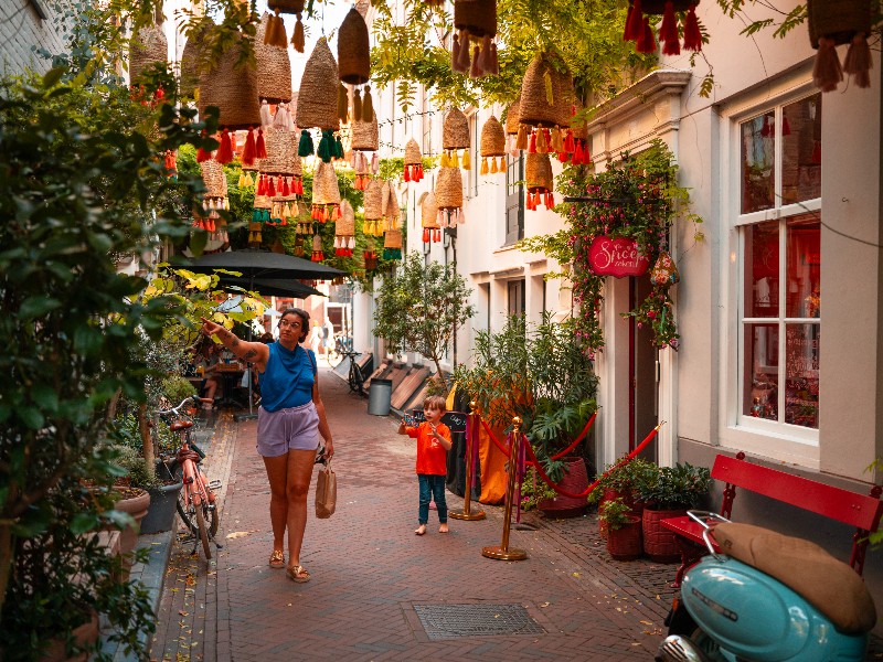 Moeder en kind lopen door de mooie Reigerstraat in Middelburg, in het centrum