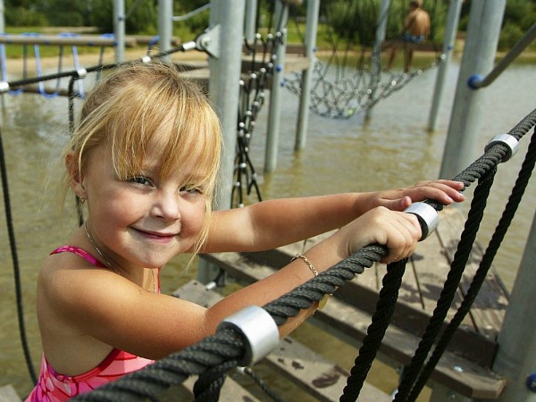 Meisje op de klimtoestellen boven het water